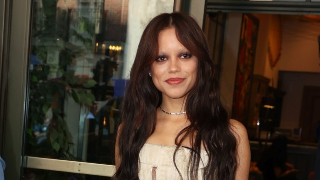 Jenna Ortega toca la cabeza en un look neo-goth con un toque corporativo