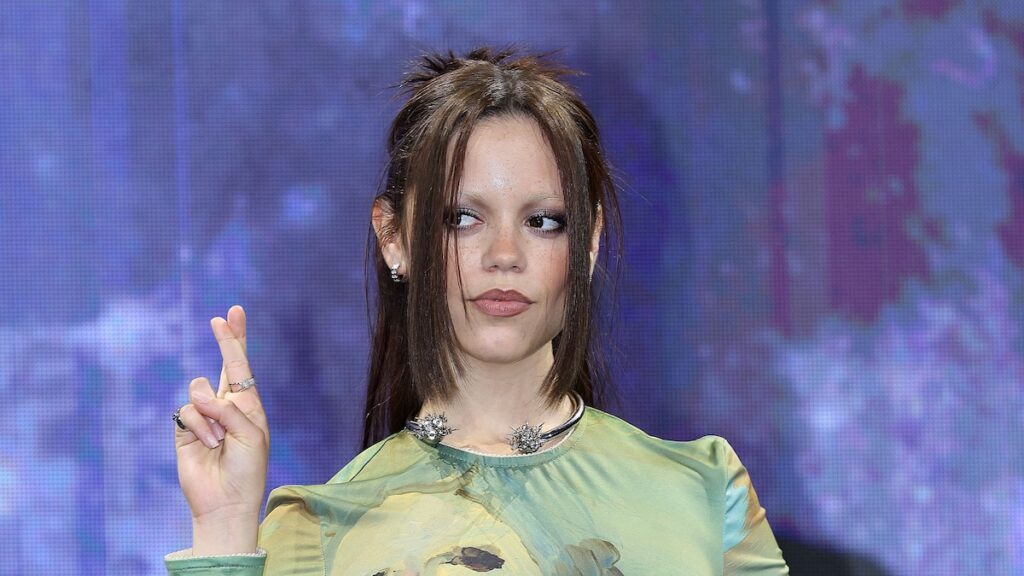 Jenna Ortega sumerge los dedos de los pies en la playa, vistiendo un look de cuero completamente negro inesperado