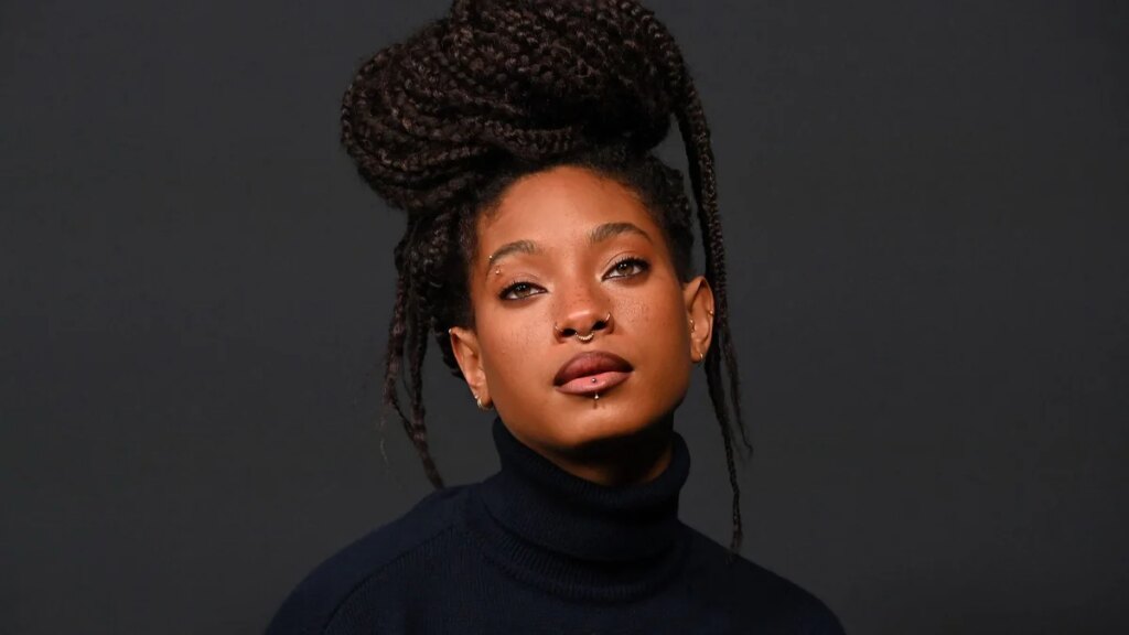 Willow Smith llama la atención con un vestido verde esmeralda y medias moradas hasta el muslo para un importante anuncio musical