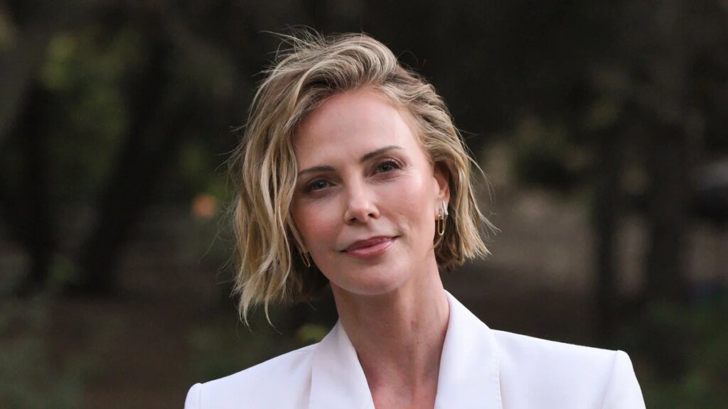 Charlize Theron se salta la camiseta con un elegante traje blanco